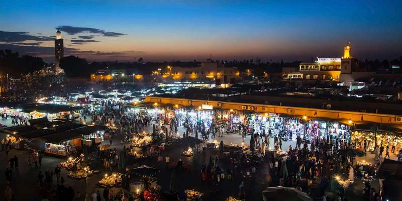 La plaza Jemaa el-Fna de Marrakech al caer la noche, con los puestos de comida iluminados y llenos de gente