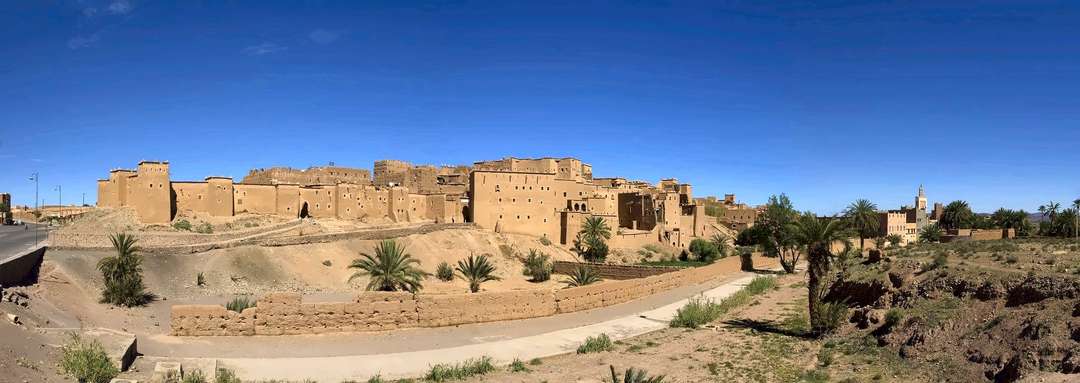 As longas paredes e torres de terra da kasbah de Taourirt, em Ouarzazate, sob um céu muito azul
